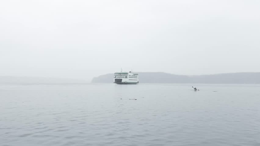 Ferry And Kayaker Navigating On Puget Sound With Dense Fog In Vashon Island Near Tacoma, Washington. wide shot