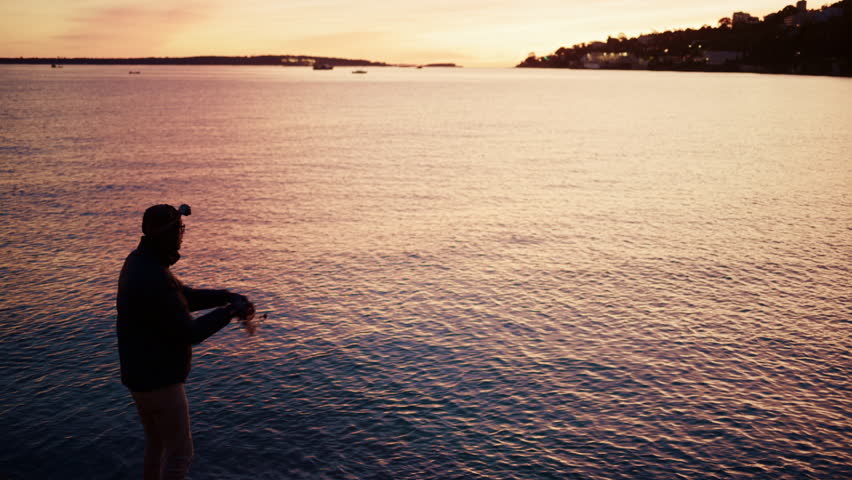 Silhouette of a man fishing in the calm Mediterranean Sea at sunrise in the South of France