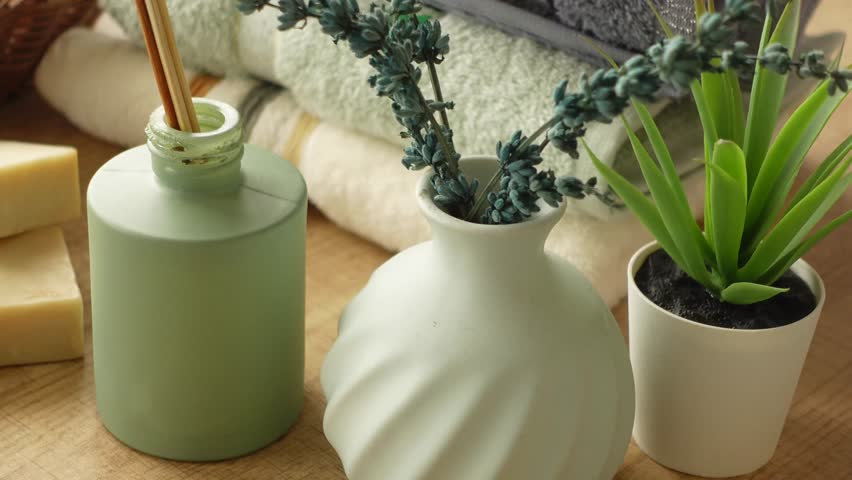 Aromatic wellness spa set with lavender oil diffuser and handmade soap bars on wooden table