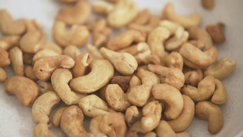 Healthy snack, hand grabbing a bunch of cashew nuts
