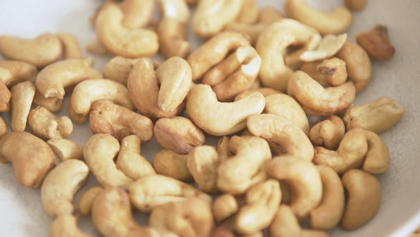 Close-up of a bunch of cashew nuts in a plate, camera zoom in