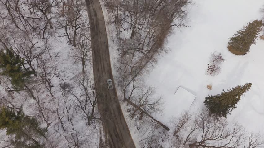 Wide sweeping aerial panorama of Madison, Wisconsin with icy lake and seasonal snow coverage.