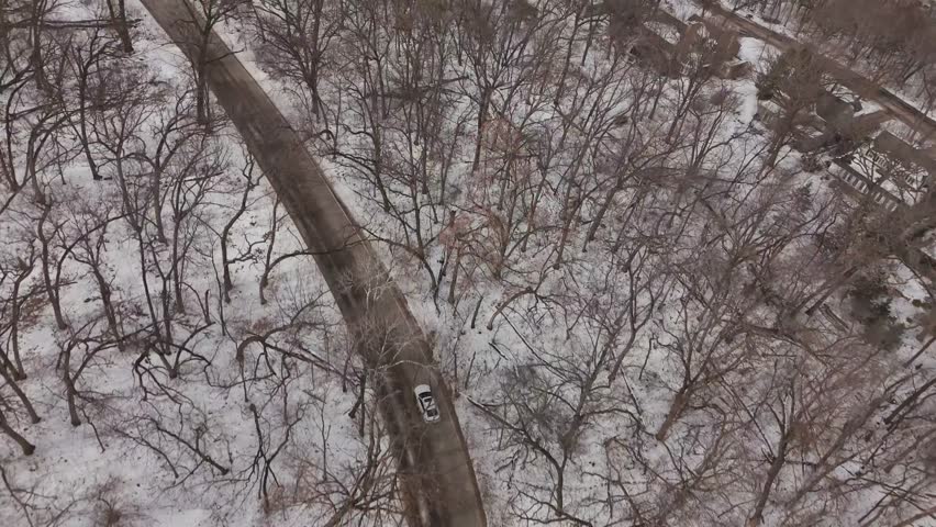 Forward cinematic drone movement toward frozen Lake Mendota and nearby campus buildings in Madison, Wisconsin.