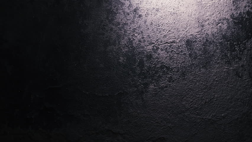 Moving bulb casting light beam across grunge wall. Dramatic scene perfect for fear, pursuit, or crime thriller narratives.