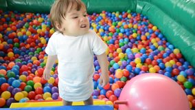 Baby playing in playground colorful ball pool