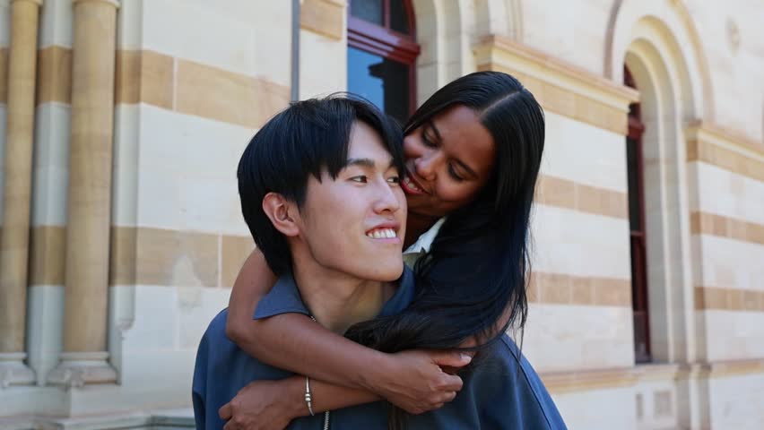 Happy Interracial Couple Enjoying Piggyback Ride Outdoors