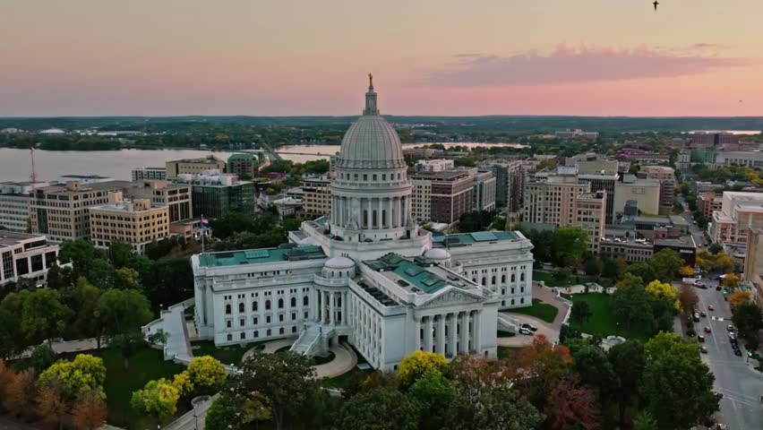 Aerial view of the Wisconsin State Capitol at sunset, highlighting its iconic dome and surrounding cityscape.