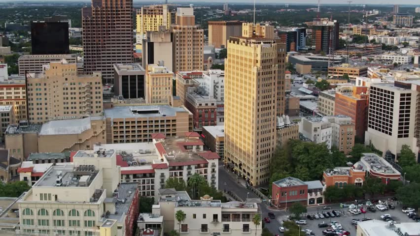 Aerial view of San Antonio cityscape at dusk, showcasing downtown buildings, skyline, and warm evening urban lights.