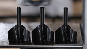 Industrial 3D printer extruder head printing multiple black plastic parts on build plate during additive manufacturing process. Close-up of heated 3D printer nozzle - Powered by Shutterstock - Get 15% off with code: PIKWIZARD15