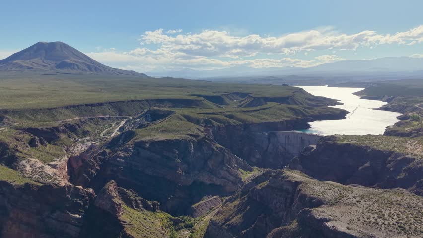 Aerial perspective of Agua del Toro dam and hydroelectric plant with Cerro Diamante volcano in the background, Mendoza.