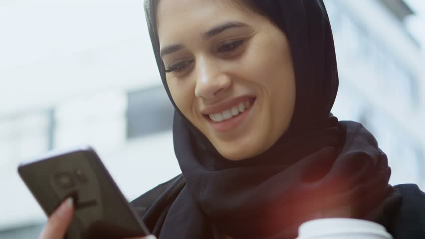 Animation of happy emoji over woman using smartphone. Global connection digital interface technology and networking concept digitally generated video.