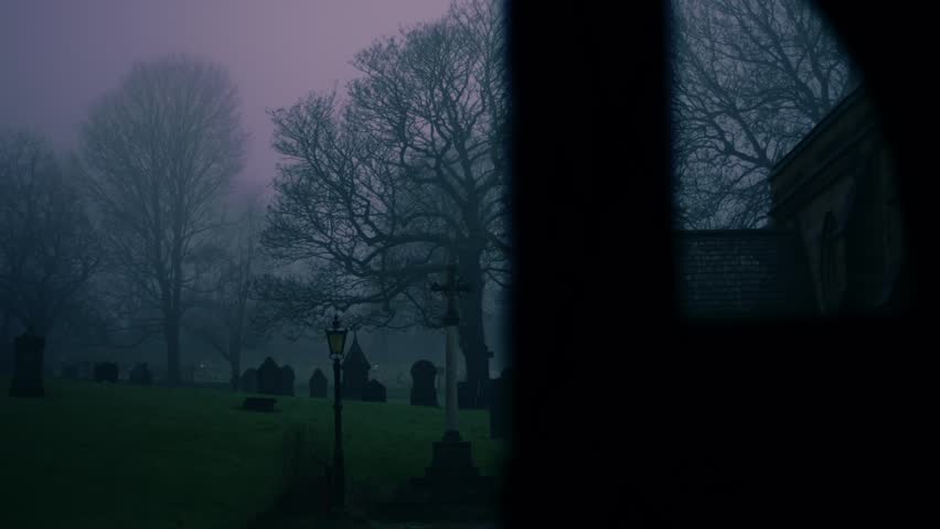 Lonely Graveyard on foggy day though view of church lych gate mdium zoom shot slow motion panning shot