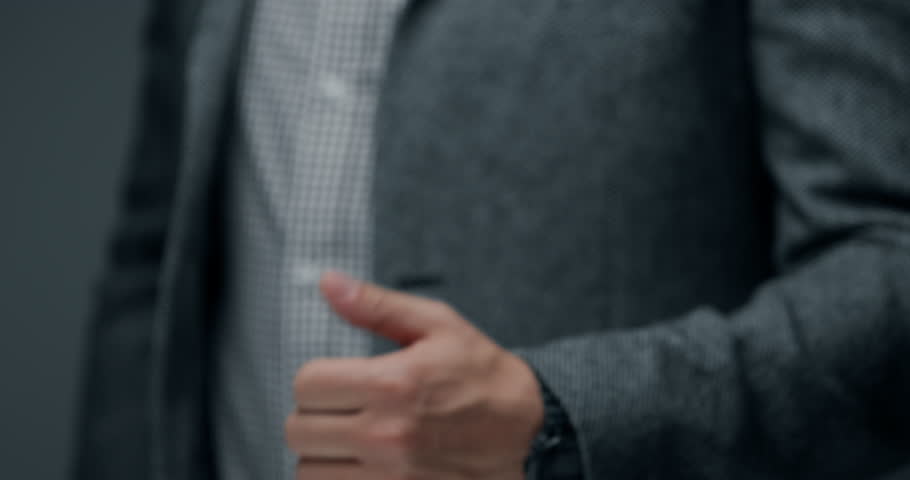 Close up of businessman in formal suit showing thumbs up gesture. Concept of approval, success, agreement, positive feedback, recommendation and business achievement.