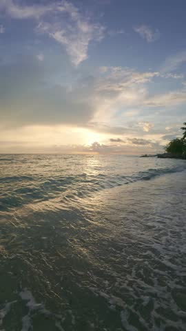 Sunset Over Ocean Waves on Sandy Beach