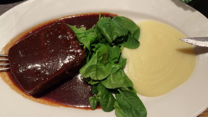 Oxtail with truffled Parmentier and a Montsant red wine sauce with with mashed potatoes and spinach. High quality 4k footage