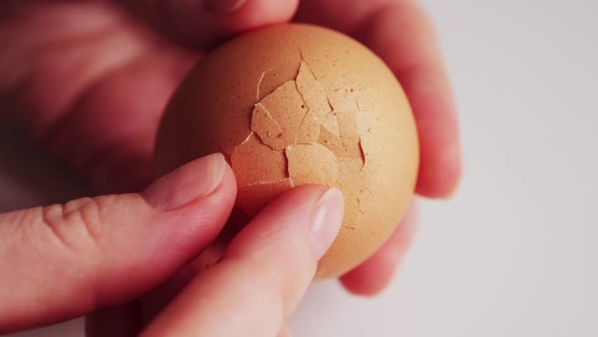 Peeling an egg close up. Boiled egg in hands. High quality 4k footage