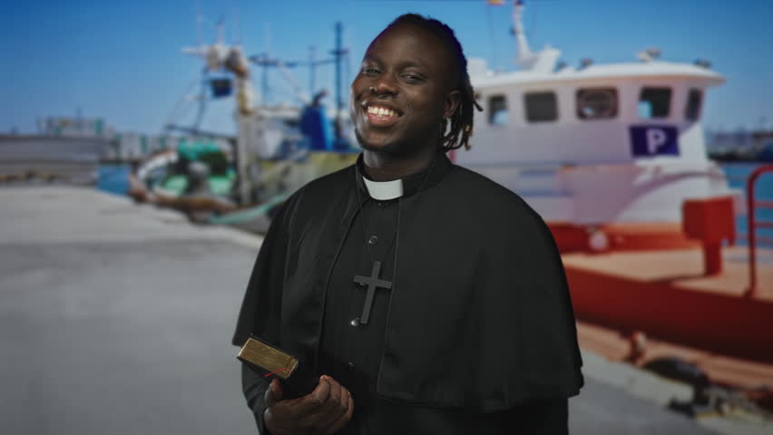 Priest man pointing hand and holding bible on street by port boats and pier, smiling toward camera; hope outreach.