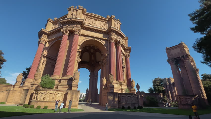 San Francisco, California; October 30 2025 Handheld tilt up reveal of the imposing Palace of Fine Arts architecture at sunset clear blue sky highlighting the majestic neoclassical stone structure
