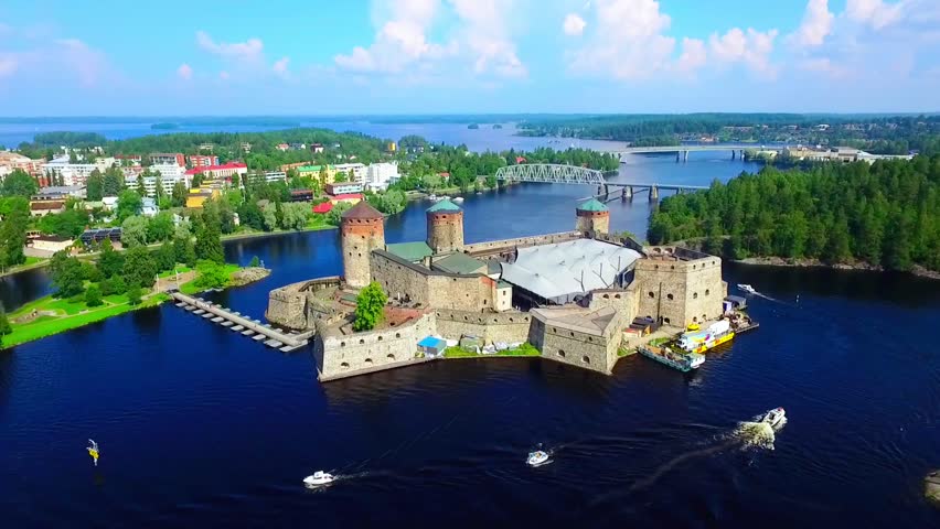 Aerial view of Olavinlinna Medieval Castle in Savonlinna. Historic Fortress Surrounded by Lush Greenery and Serene Water Bodies in Finland