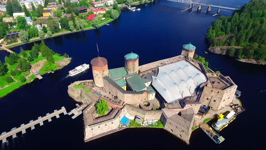 Aerial view of Olavinlinna Medieval Castle in Savonlinna, Historic Castle Surrounded by Water and Lush Greenery on a Clear Day, Finland