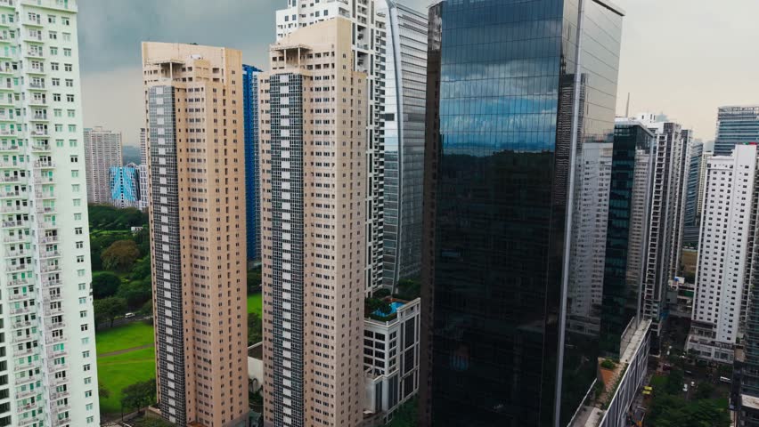 Aerial shot flying toward skyscrapers in Bonifacio Global City under cloudy sky