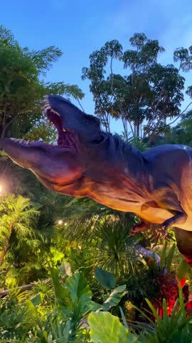 A dynamic dinosaur model in an outdoor park, captivating the audience as it moves its head and opens its mouth, adding a thrilling prehistoric element to the park