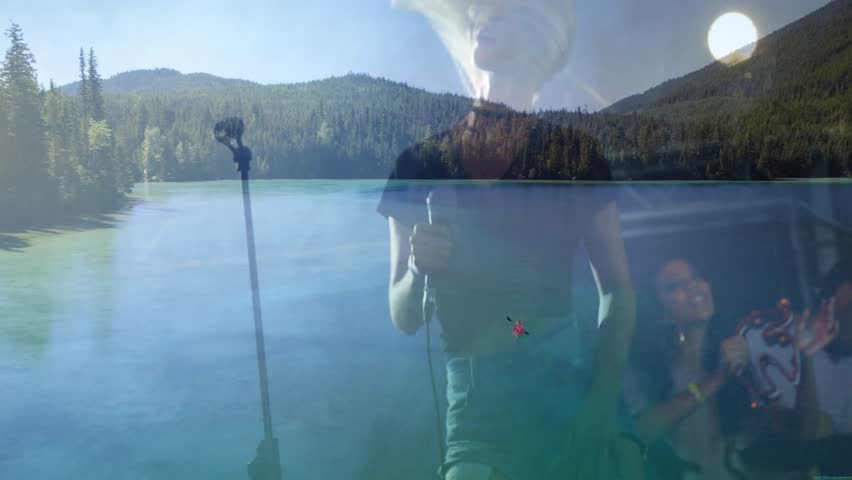 Woman vocalist performing with bandmates on stage merging lake with metal truss lighting for music. Performance, live music, outdoor landscape, nature backdrop, stage equipment, musical ensemble,