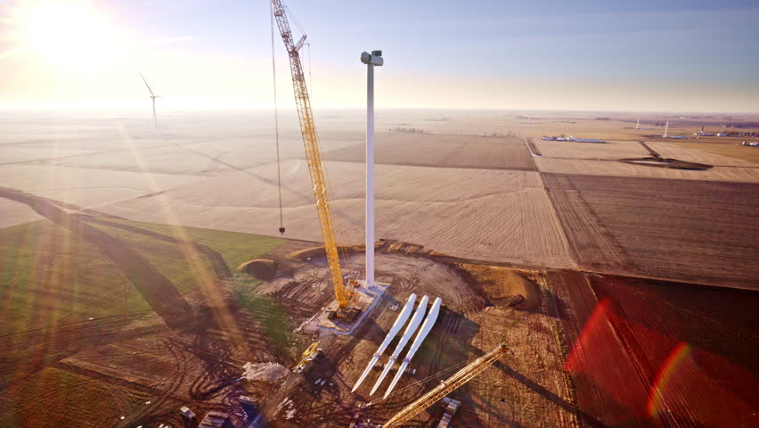 Drone footage looping around wind turbines still being constructed