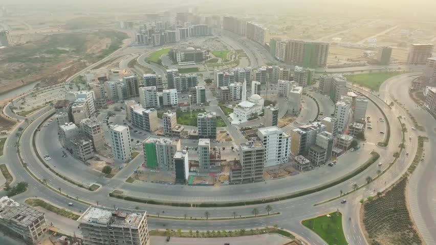 Aerial circular dolly drone shot of Medway Commercial Hub in Karachi, Pakistan showcasing modern business buildings, urban office complex and contemporary commercial architecture exterior with dynamic city surroundings under clear daylight, captured on 03 August 2025.