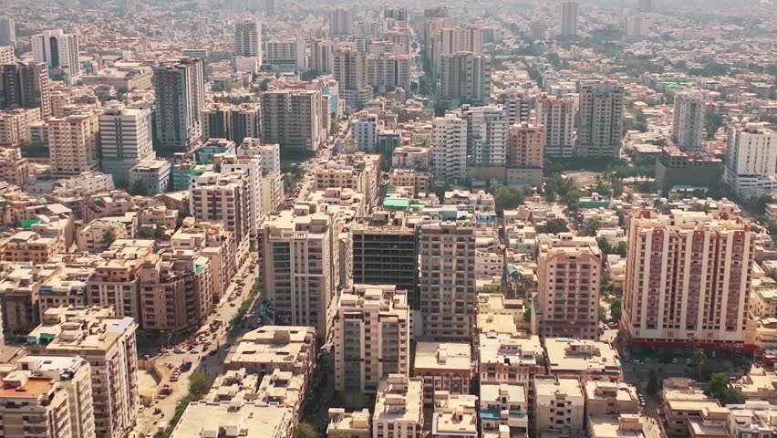 Beautiful aerial master shot of Karachi, Pakistan showcasing environmental urban landscape, expansive coastal megacity sky line and evolving city development panorama along the Arabian Sea under golden sunset light, captured on 11 November 2025.