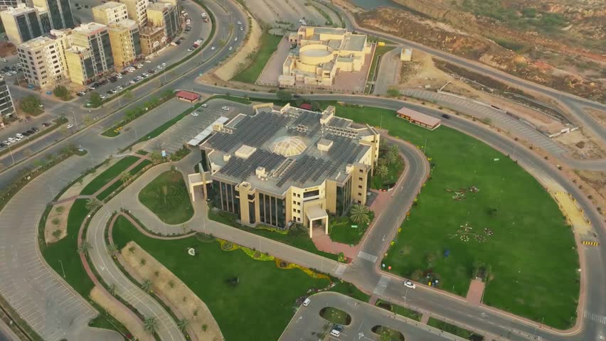 Aerial drone view of Karachi, Pakistan revealing vibrant urban sky line, modern architecture, expansive coastal water front and dynamic city landscape along the Arabian Sea under clear blue sky, captured on 12 March 2025 in high resolution detail.