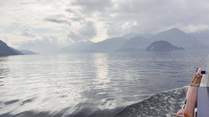 Majestic mountain peaks rising above a clear lake under bright blue sky. Scenic untouched landscape