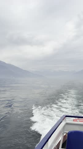 Large ship moving across a lake surrounded by mountains. Scenic outdoor landscape with calm water and natural reflections