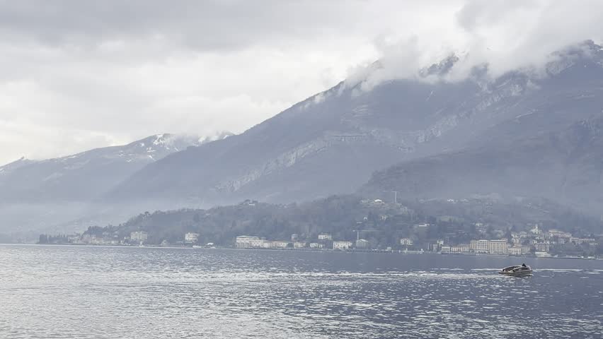 Natural mountain landscape with calm lake water reflecting high peaks and bright sky