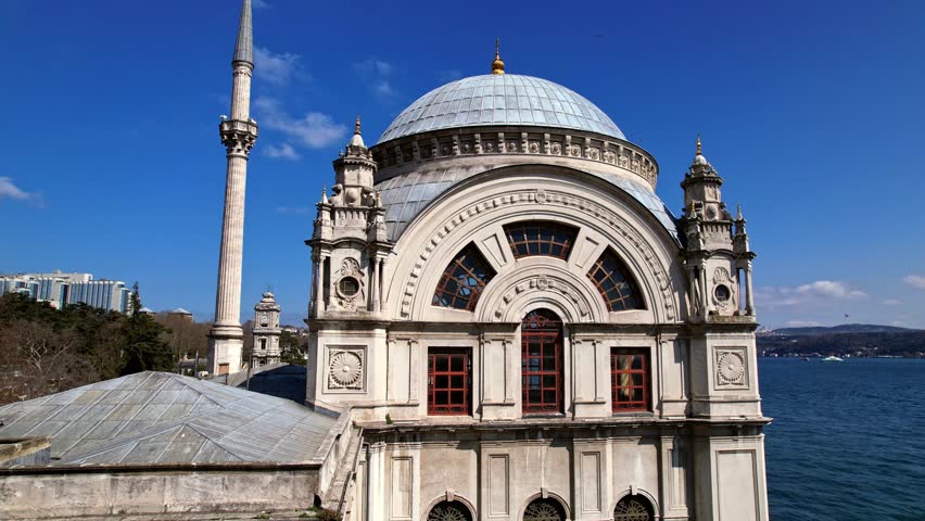 Close-up video frame highlighting the dome, arched windows, and stone decorations of Dolmabahce Mosque, showcasing refined Ottoman architecture along the Bosphorus waterfront in Istanbul.