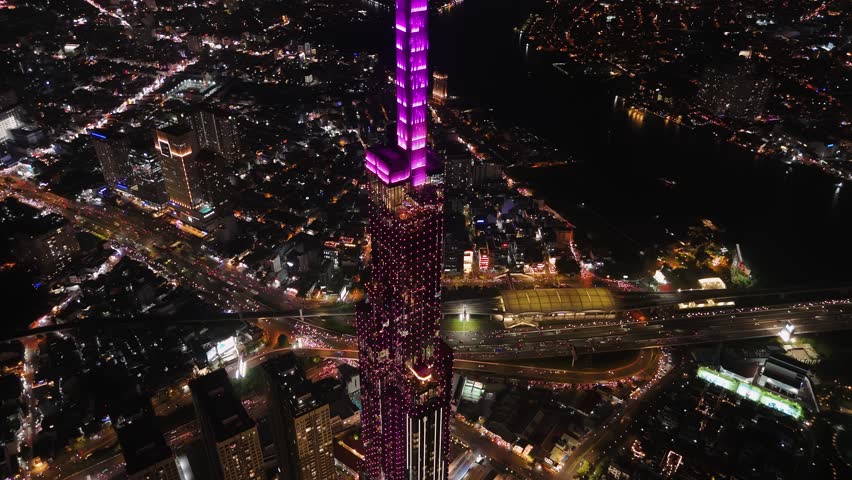 Aerial night view of landmark skyscraper in ho chi minh city, vietnam, with illuminated skyline on saigon river.