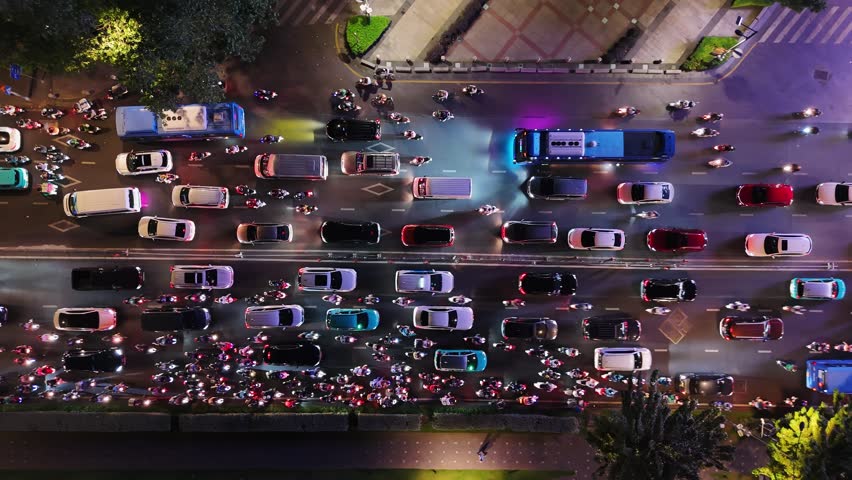 Top down aerial view of night traffic in ho chi minh city, vietnam. Hundreds of cars, buses, and motorbikes with headlights on.