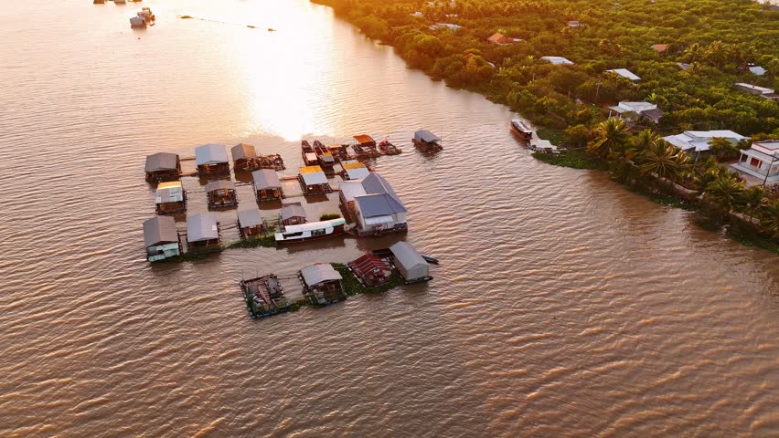 Aerial view of floating village on the mekong river in vietnam during sunset with beautiful golden light.