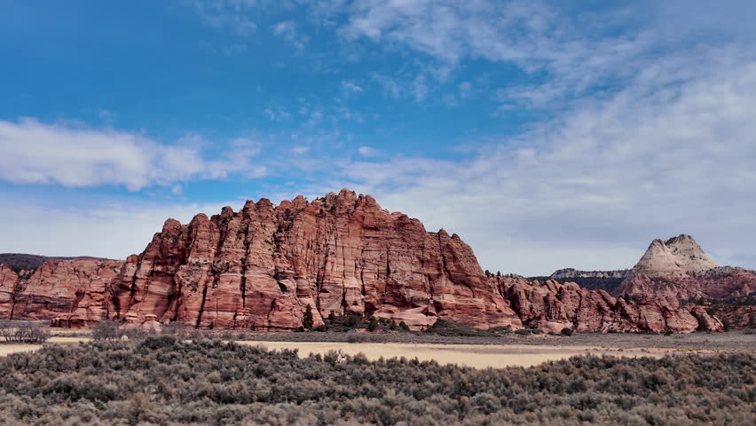 Driving view of sagebrush moving by looking in the Zion wilderness and red rock desert in Utah.
