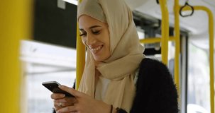 woman wearing hijab checking smartphone inside city bus, displaying technology network overlay. Commuter, urban, transportation, modern, connectivity, public, lifestyle - Powered by Shutterstock - Get 15% off with code: PIKWIZARD15