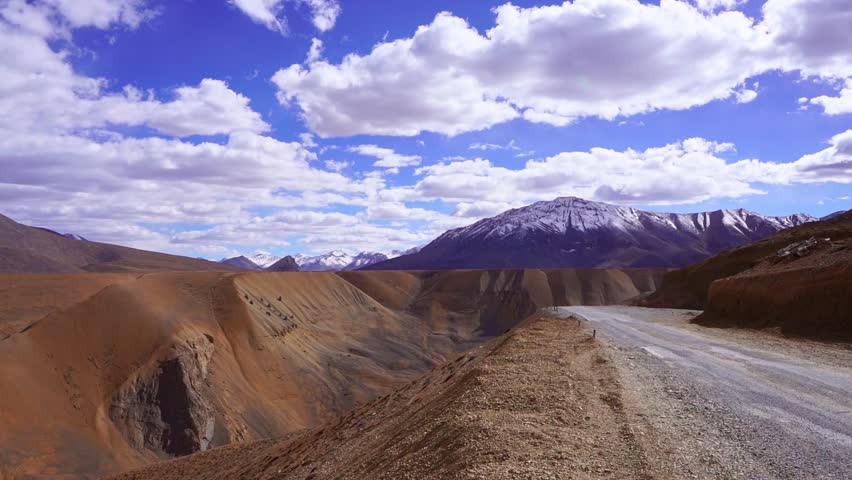 Breathtaking landscape of a beautiful valley in Leh, Ladakh with towering Himalayan mountains in the background. Wide scenic view of the rugged mountains, clear sky, and vast natural terrain of the high-altitude Himalayan region. Stunning travel destination showcasing the dramatic beauty and wilderness of Ladakh in northern India.