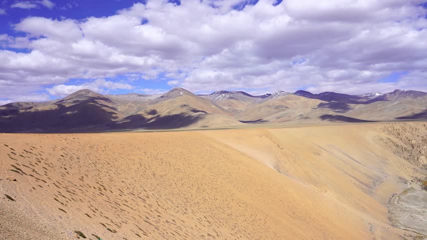 Breathtaking landscape of a beautiful valley in Leh, Ladakh with towering Himalayan mountains in the background. Wide scenic view of the rugged mountains, clear sky, and vast natural terrain of the high-altitude Himalayan region. Stunning travel destination showcasing the dramatic beauty and wilderness of Ladakh in northern India.