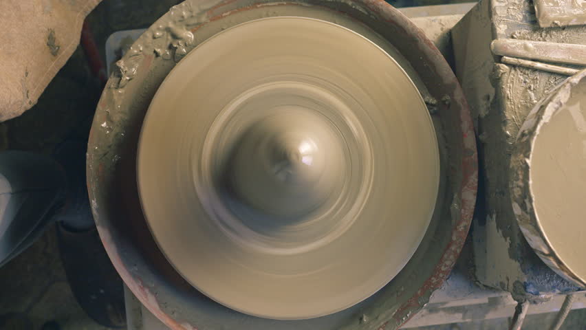 A close-up of a spinning pottery wheel, showcasing the creation of a ceramic piece. The wheel
