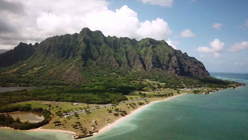Hawaiian Mountains with an ocean around Kualoa Ranch, Oahu, drone footage, Hawaii. Majestic green mountains and turquoise ocean. Filming location in Hawaii. High quality 4k footage