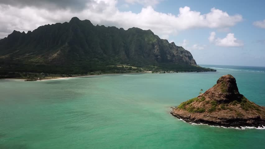 Hawaiian Mountains with an ocean around Kualoa Ranch, Oahu, drone footage, Hawaii. Majestic green mountains and turquoise ocean. Filming location in Hawaii. High quality 4k footage