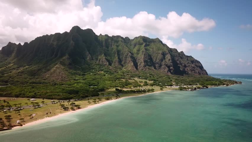 Hawaiian Mountains with an ocean around Kualoa Ranch, Oahu, drone footage, Hawaii. Majestic green mountains and turquoise ocean. Filming location in Hawaii. High quality 4k footage