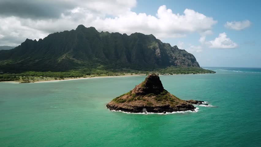 Hawaiian Mountains with an ocean around Kualoa Ranch, Oahu, drone footage, Hawaii. Majestic green mountains and turquoise ocean. Filming location in Hawaii. High quality 4k footage