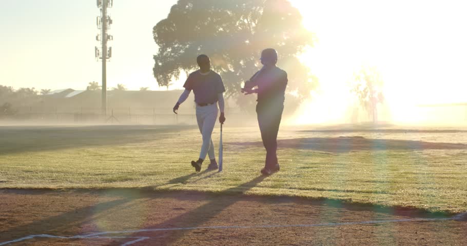 Striding African American coach and male player entering batter