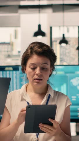 Vertical Video Portrait of work team analyzing data analysis results and KPI metrics in corporate workspace. Diverse business people collaborating on strategy, performance reporting and development.