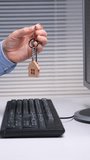 Vertical video person holding house shaped keychain and keys over a laptop keyboard while browsing property listings, comparing rentals or mortgage options for a future home purchase or move - Powered by Shutterstock - Get 15% off with code: PIKWIZARD15
